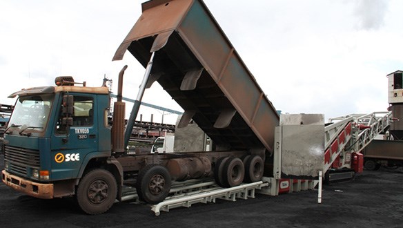 loading iron ore to barge from trucks